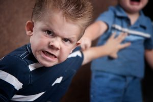 Angry little boy glaring and fighting with his brother